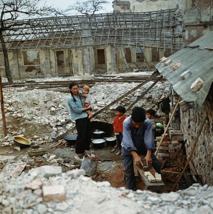 Căn nhà của gia đình người dân Hải Phòng bị phá hủy hoàn toàn năm 1973. Người chồng đang bào lại những mảnh gỗ có thể dùng lại được. Ảnh: Werner Schulze-dpa-Corbis.